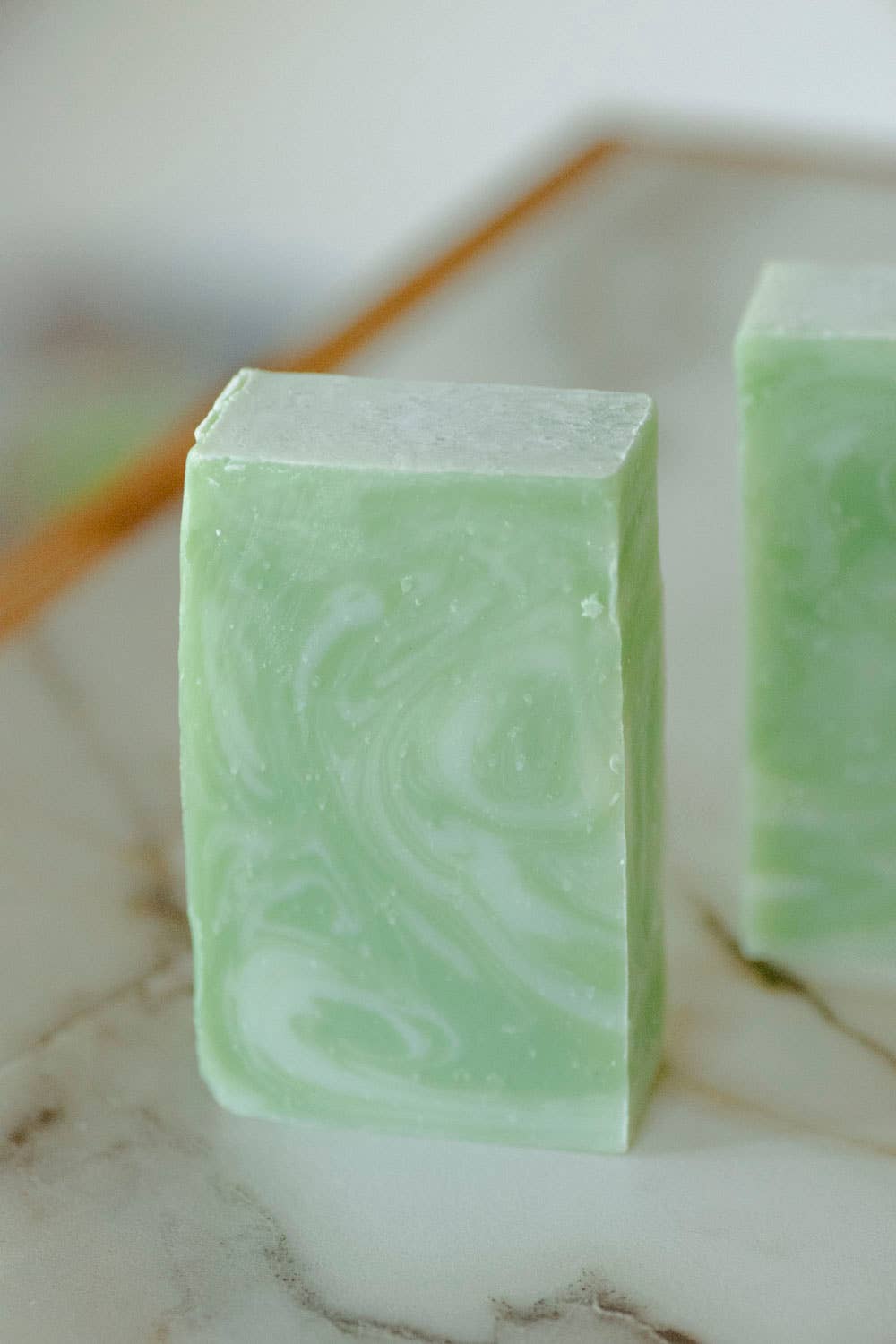 Green marbled soap bar on a marble surface