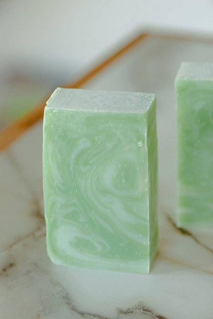 Green marbled soap bar on a marble surface