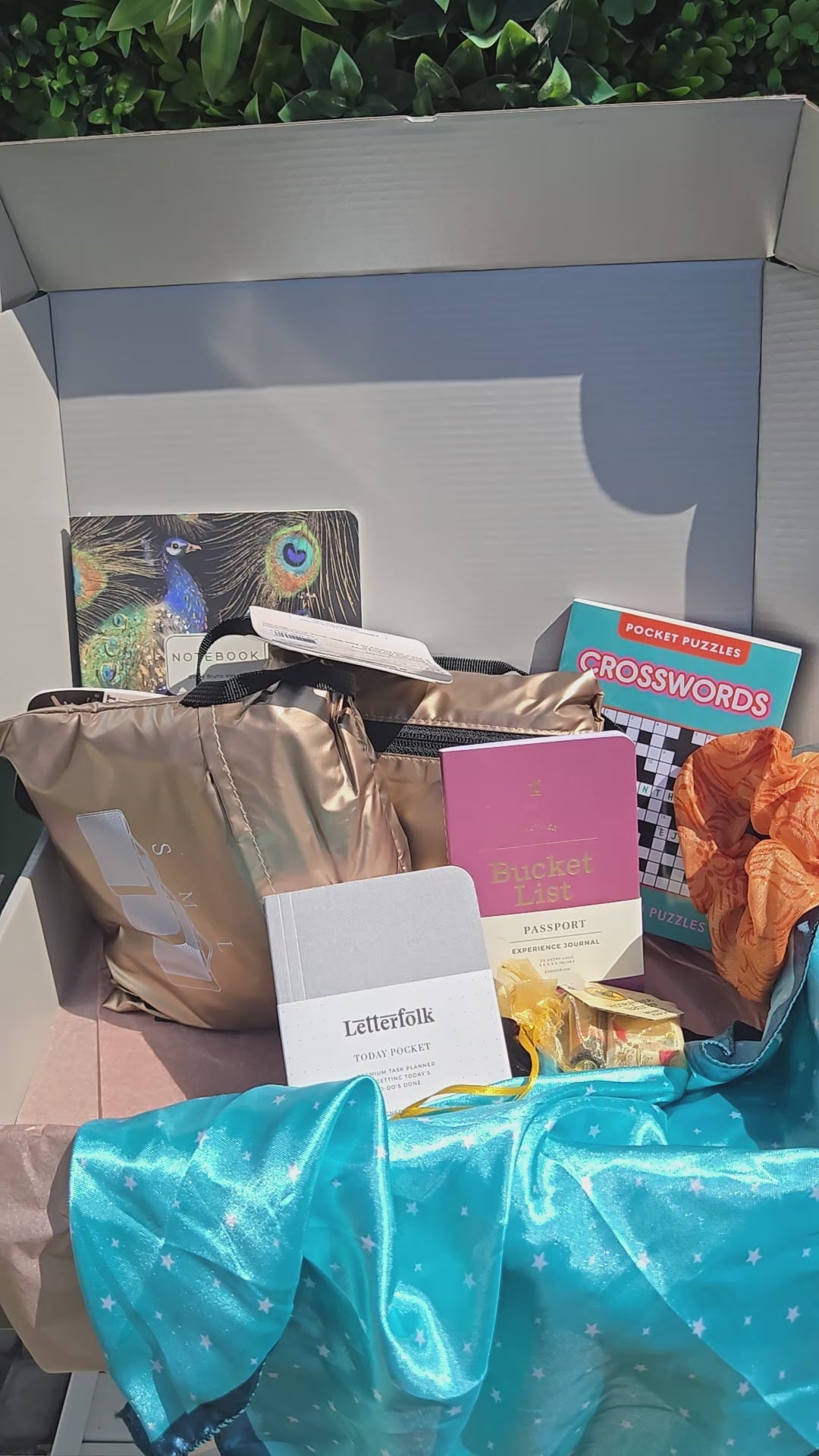 unboxing video of the getaway kit with packed folding duffle, packing cubes, clear tsa friendly waist pack, peacock notebook, hand fan, crossword puzzle, scrunchie and scarf.